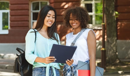 Two community college students looking at a schedule. 